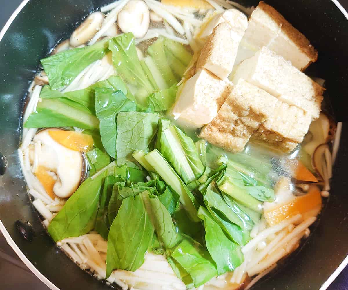 水を入れ、ふつふつとしてきたら、小松菜・豆腐を入れて1分程煮込む。