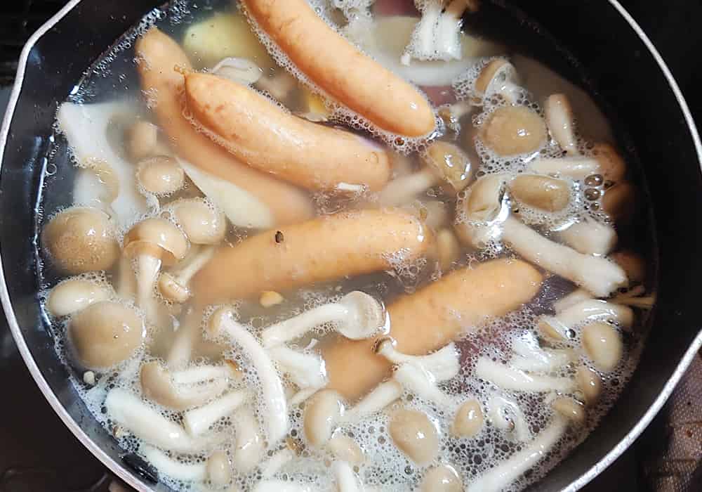 具材が柔らかくなってきたら、ウィンナー、しめじを入れる。